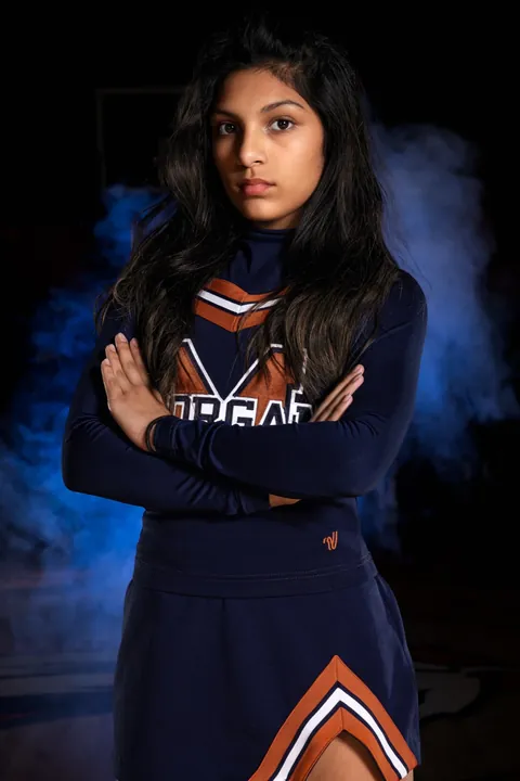 Studio portrait of a cheerleader in a navy uniform